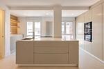 Cocina minimalista con isla central y ventanales