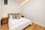 Dormitorio minimalista con cama c&aacute;lida y luz suave