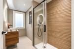 Ba&ntilde;o moderno con espejo iluminado y ducha de cristal