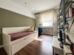 Dormitorio verde con cama nido y escritorio