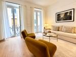 Sal&oacute;n moderno con sillones dorados y ventanales