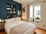 Dormitorio moderno con pared azul y cama acogedora