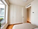 Dormitorio minimalista con armario blanco y luz natural