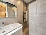 Ba&ntilde;o moderno de piedra gris y luz c&aacute;lida