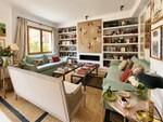 Sal&oacute;n acogedor con sof&aacute;s verdes y arte