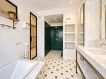 Ba&ntilde;o moderno con azulejos verdes y m&aacute;rmol