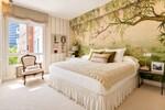 Dormitorio elegante con mural bot&aacute;nico y luz natural